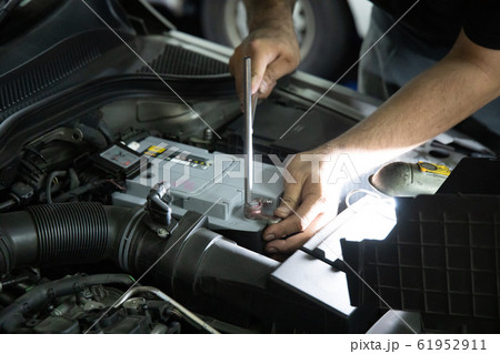Mechanic inspect and replace car battery at garage Mechanic inspect and replace car battery at garage 61952911