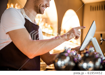Caucasian waiter looking at screen in beautiful cafe indoors 61954452