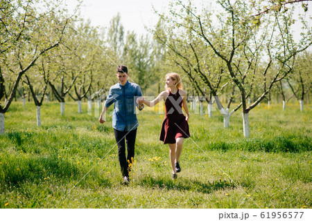 Beautiful couple spend time in a summer park Beautiful couple spend time in a summer park 61956577