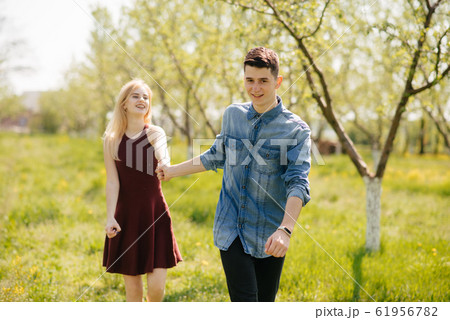 Beautiful couple spend time in a summer park Beautiful couple spend time in a summer park 61956782