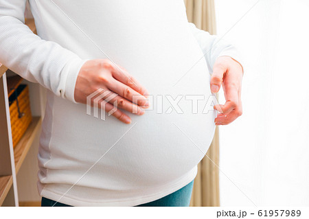 お腹を掻く妊婦 お腹を掻く妊婦 61957989