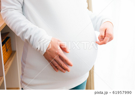 お腹を掻く妊婦 お腹を掻く妊婦 61957990