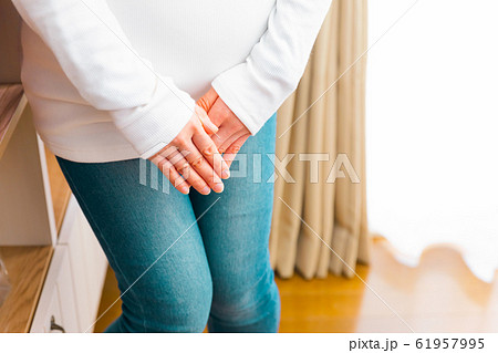 股間を抑える妊婦　破水　尿意　尿漏れ　おしるし 61957995