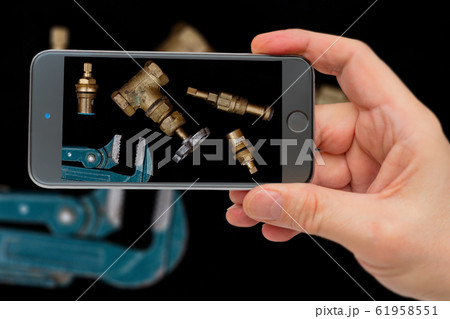 Plumbing tools on black background. Faucets, valve, pipe wrench to repair water supply system. Plumber tools on smartphone screen. Plumbing tools on black background. Faucets, valve, pipe wrench to repair water supply system. Plumber tools on smartphone screen. 61958551