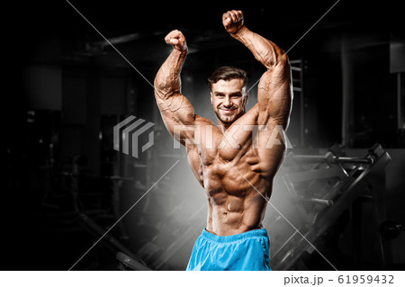 good looking fitness man pumping up muscles 61959432