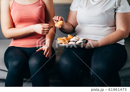 overweight woman eating junk snacks and sweets overweight woman eating junk snacks and sweets 61961473
