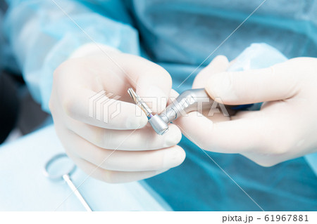 Dentist's hands in sterile gloves close-up, with Dentist's hands in sterile gloves close-up, with 61967881