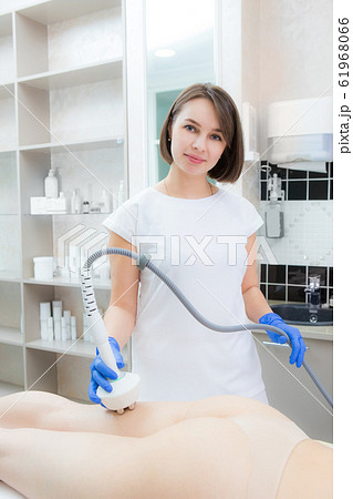 The cosmetologist reduces cellulite on the 61968066