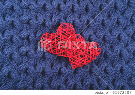 Two red hearts on the blue knit background. Two red hearts on the blue knit background. 61972507