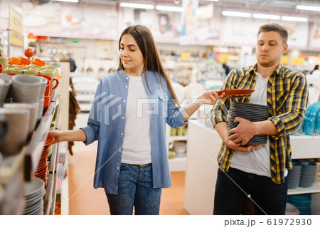 Young couple choosing plates in houseware store Young couple choosing plates in houseware store 61972930