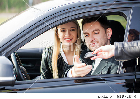 Happy couple buy new modern black car 61972944