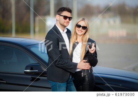Happy couple buy new modern black car Happy couple buy new modern black car 61973030