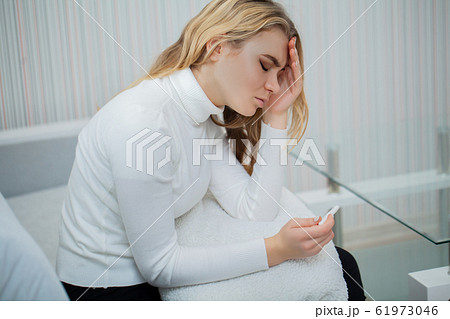 Worried sad woman Looking at a Pregnancy Test after result. Worried sad woman Looking at a Pregnancy Test after result. 61973046