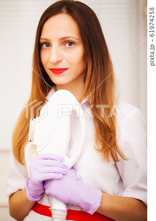 Woman doctor displaying machine for laser hair removal Woman doctor displaying machine for laser hair removal 61974258