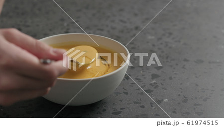 man eating pumpkin cream soup in white bowl on terrazzo countertop man eating pumpkin cream soup in white bowl on terrazzo countertop 61974515