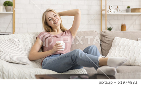 Relaxed girl drinking coffee or tea at home 61974833