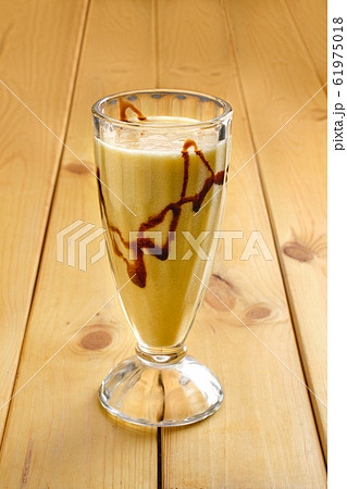 Glass of banana smoothie on wooden table Glass of banana smoothie on wooden table 61975018