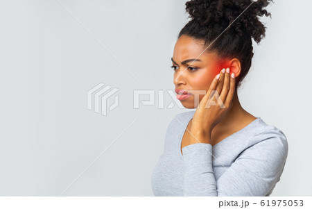 Young woman suffering from acute ear pain 61975053