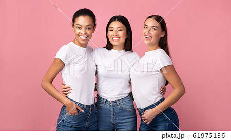 Three Women Embracing Standing In Studio On Pink Background, Panorama Three Women Embracing Standing In Studio On Pink Background, Panorama 61975136