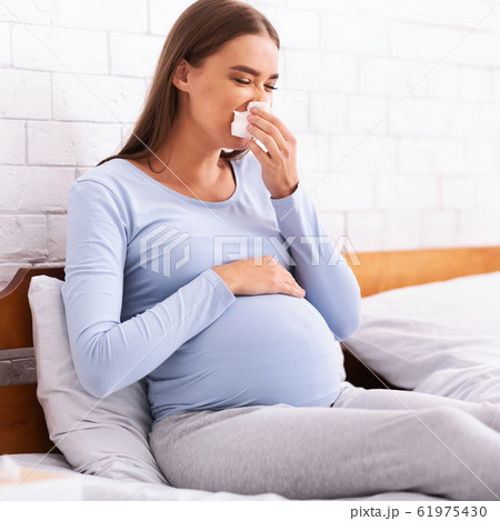 Sick Pregnant Lady Blowing Nose In Handkerchief Sitting In Bedroom 61975430