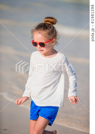 Adorable little girl at beach during summer vacation Adorable little girl at beach during summer vacation 61981398