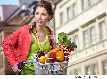 Pretty young woman with bicycle and groceries in Pretty young woman with bicycle and groceries in 61982567