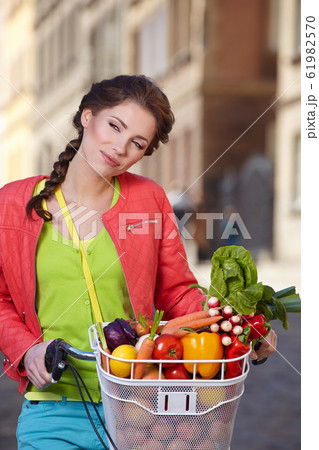 Pretty young woman with bicycle and groceries in Pretty young woman with bicycle and groceries in 61982570