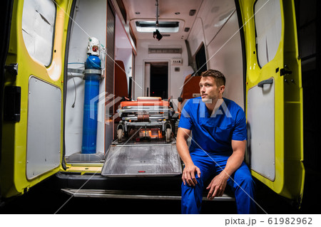 Corpsman sit on the ambulance car and think 61982962