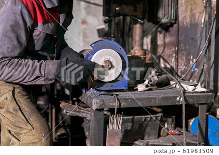 sharpening a tool on a grinding wheel 61983509