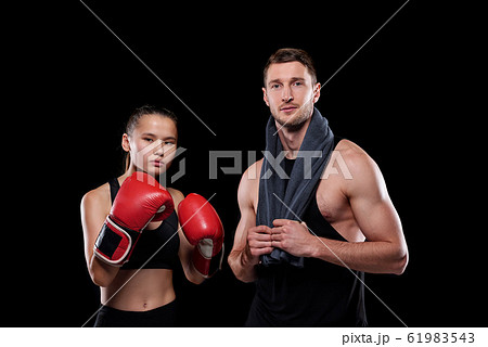 Sporty girl in red boxing gloves and her muscular boyfriend with towel Sporty girl in red boxing gloves and her muscular boyfriend with towel 61983543