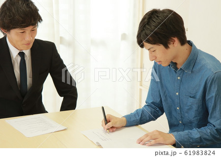 契約書にサインする若い男性 61983824