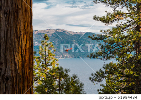 A red helicopter flies over Lake Tahoe near Crystal Bay 61984434