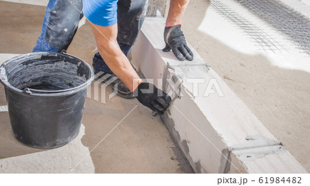 Bricklayer laying blocks 61984482