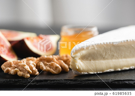 Brie or camembert cheese, walnuts, honey, figs Brie or camembert cheese, walnuts, honey, figs 61985635