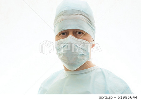 Portrait of calm surgeon in sterile gown and surgical mask Portrait of calm surgeon in sterile gown and surgical mask 61985644