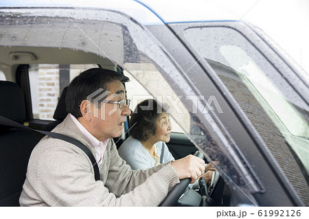 雨の日に車の運転をするシニア　高齢者ドライバーイメージ 61992126