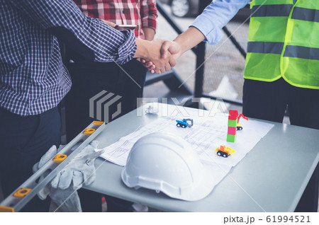 engineers and businessman shaking hands for make an agreement in investment about construction project. success dealing greeting and partner concept. engineers and businessman shaking hands for make an agreement in investment about construction project. success dealing greeting and partner concept. 61994521