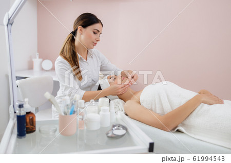 Beautiful young woman having face massage at spa salon Beautiful young woman having face massage at spa salon 61994543