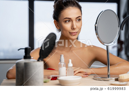 Pretty girl sitting at a dressing table 61999983