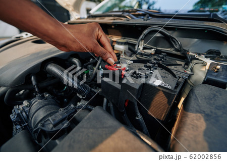 Woman checking car battery 62002856