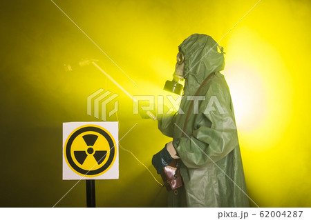 Radiation and danger concept - Man in the gas mask and chemical suit. The worker doing measure radioactivity Radiation and danger concept - Man in the gas mask and chemical suit. The worker doing measure radioactivity 62004287
