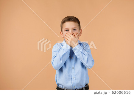child closes her mouth with his hand child closes her mouth with his hand 62006616
