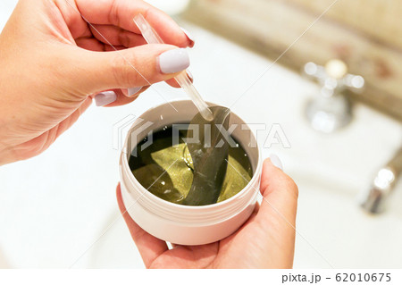 Female hands are taking eye patches out from the 62010675