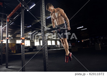Young healthy male athlete doing exercises in the gym Young healthy male athlete doing exercises in the gym 62011072