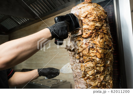 Chef hands chop chicken for doner kebab 62011200