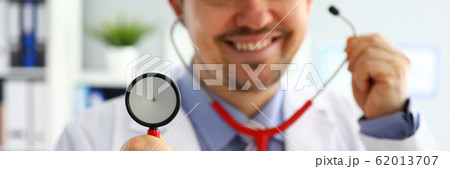 Handsome male doctor put on stethoscope closeup Handsome male doctor put on stethoscope closeup 62013707