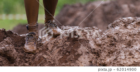 Mud race runners detail of the legs, muddy running shoes a run in the mud 62014900