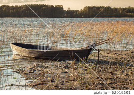 Boat moored on the mudy shore lake Boat moored on the mudy shore lake 62019101