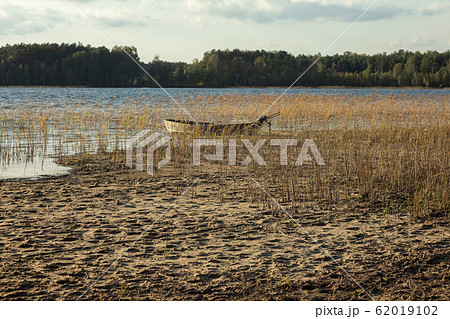 Boat moored on the mudy shore lake Boat moored on the mudy shore lake 62019102
