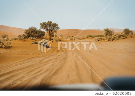 Deep car tire track on desert sand Deep car tire track on desert sand 62020005